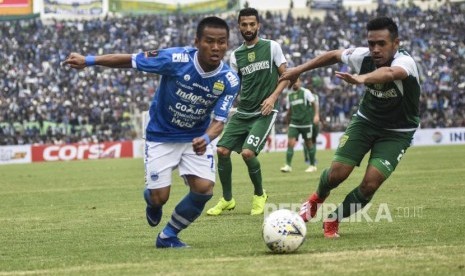 Gelandang Persib Bandung Beckham Putra Nugraha (kiri) berebut bola dengan pesepakbola Persebaya Surabaya saat laga lanjutan Grup A Piala Presiden 2019 di Stadion Si Jalak Harupat, Kabupaten Bandung, Kamis (7/3).