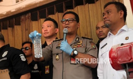 Kabid Humas Polda Metro Jaya Kombes Pol Argo Yuwono (tengah) Kepala BBPOM DKI Jakarta Sukriadi Darma dan jajarannya memperlihatkan barang bukti minuman beralkohol (CIU) saat rilis pengungkapan industri rumahan ciu tanpa izin edar dari BPOM RI di kawasan Pekojan, Jakarta, Kamis (3/5).