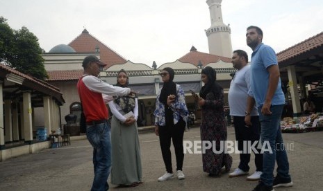 Pemandu wisata memberikan informasi kepada peserta Muslim Exchange Program (MEP) saat berkunjung ke Masjid Luar Batang, Jakarta, Jumat (16/3).