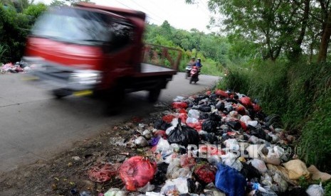 Sejumlah kendaraan melintas didekat sampah yang dibuang di pinggir jalan. (Ilustrasi)