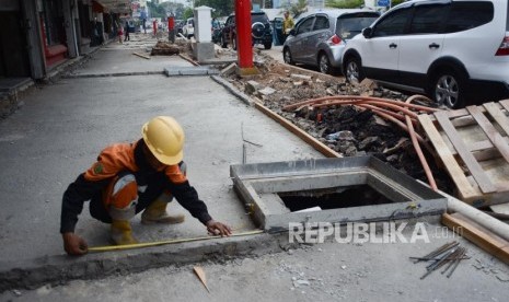 Pekerja menyelesaikan pembuatan trotoar di kawasan Cikini, Jakarta.