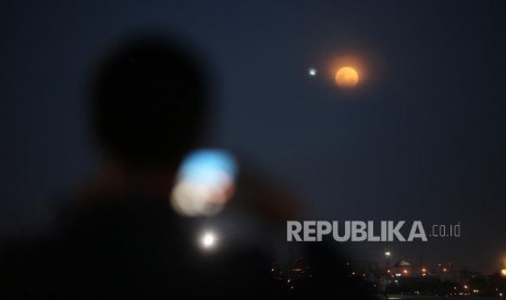 Warga memfoto penampakan gerhana bulan total super blue blood moon di Kawasan Acol, Jakarta, Rabu (31/1).