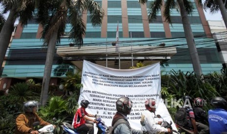 Pengendara motor melintas didepan spanduk pemberitahuan penutupan Hotel Alexis terpampang di pinggir jalan depan Alexis. Jakarta, Rabu (28/3).