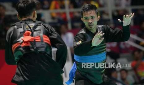 Pesilat Indonesia Abdul Malik (pita biru) bertanding melawan pesilat Malaysia Muhammad Faizul M Nasir pada babak final cabang pencak silat putra kelas B 50-55 kg Asian Games 2018 di Padepokan Pencak Silat, TMII, Jakarta, Senin (27/8).