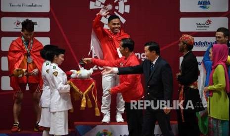 Lifter Indonesia  Eko Yuli  Irawan   (tengah)bersiap menerima medali emas yang diberikan langsung oleh Presiden Republik Indonesia Joko Widodo   usai memenang kan pertandingan  di cabang angkat besi putra nomor 62 Kg Asian Games 2018 di Hall A Kemayoran, Jakarta, selasa (21/8).