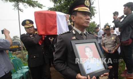 Anggota Kepolisian membawa  foto  dan  Jenazah korban jatuhnya pesawat Lion Air PK-LQP  AKBP Sekar Maulana saat pemakaman di TPU Karet Bivak, Jakarta, Kamis (8/11).