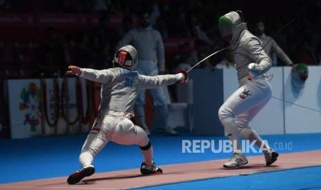 Atlet Anggar Indonesia  Fardhani Mochammad Nizar(kiri) melawan  atlet Anggar Iran Farzad Baher Arasbaran (kanan) dalam  pertandingan Perdelapan Final  cabang anggar sabre beregu putera  Asian Games di JCC, Jakarta,  Kamis (23/8).