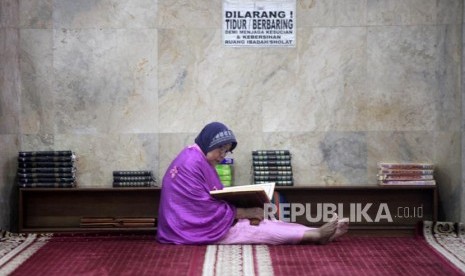 Seorang jamaah membaca Alquran seusai shalat di Masjid Sunda Kelapa, Jakarta, Senin (26/11).