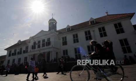 Warga menaiki sepeda di kawasan Kota Tua, Jakarta Barat, Ahad (3/12).