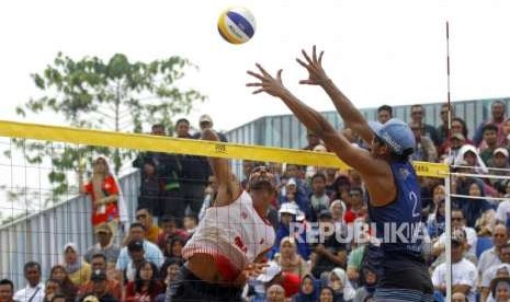 Lolos ke Semi Final. Atlet Bola Voli Pantai Indonesia Gilang Ramadhan melakukan blok bola saat bertanding melawan Tim Oman pada cabang Voli Pantai nomor putra Asian Games 2018 di Komplek Olahraga Jakabaring, Palembang, Sabtu (25/8).