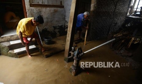 Warga saat membersihkan sisa banjir yang menggenangi kawasan Kampung Melayu, Jakarta, Senin (12/11).