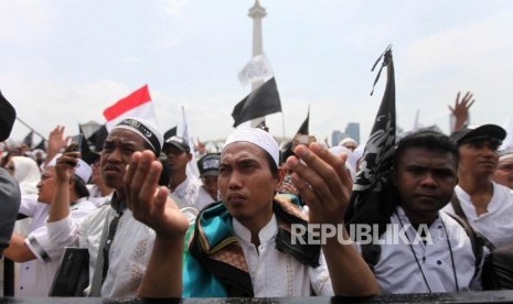 Peserta berdoa saat mengikuti reuni aksi 212 di Lapangan Monumen Nasional, Jakarta, Ahad, (2/12).