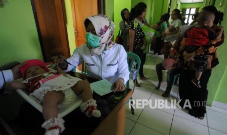 Balita saat ditimbang berat badannya sebelum melakukan imunisasi difteri di Puskemas Cimanggis, Depok, Jawa Barat, Rabu (6/12).