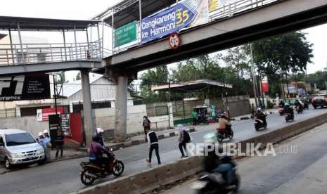 Warga melintas dibawah jembatan penyeberangan orang (JPO) yang rusak akibat ditabrak truk kontainer di Halte bus Transjakarta Dispenda Samsat barat, Daan Mogot Jakarta, Senin (3/9).