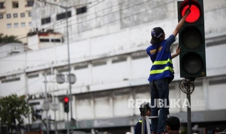 Petugas Dinas Perhubungan DKI Jakarta memperbaiki lampu pengatur lalu lintas di Jalan Asemka, Jakarta, Selasa (13/2).