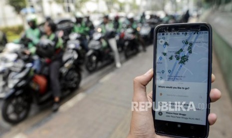 Calon penumpang memesan ojek online di kawasan Palmerah, Jakarta, Selasa (3/9).