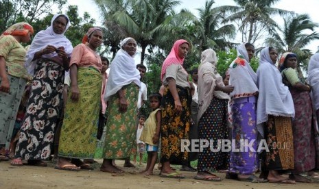 Warga muslim rohingya antre mendapatkan bantuan makanan dari sejumlah lembaga zakat yang tergabung dalam Indonesian Humanitarian Alliance (IHA) di Sittwe, Myanmar.