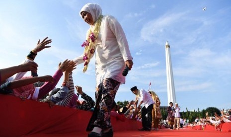 Gubernur Jawa Timur Khofifah Indar Parawansa (kiri) bersama Wakil Gubernur Jawa Timur Emil Elestianto Dardak (kedua kiri) menyapa warga di kawasan Tugu Pahlawan, Surabaya, Jawa Timur, Kamis (14/2/2019).