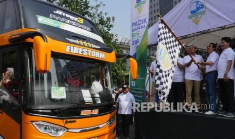 Wakil Gubernur DKI Jakarta Sandiaga Uno (ketiga kanan) bersama Direktur Kepesertaan BPJS Ketenagakerjaan E Ilyas Lubis (kedua kanan) mengibarkan bendera pada acara pelepasan Mudik Bersama BPJS Ketenagakerjaan Tahun 2018, di  Lapangan Parkir Polda Metro Jaya, Jakarta, Sbtu (9/6).