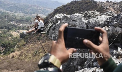 Wisatawan mancanegara berfoto saat menaiki tebing karst Citatah di Wisata Alam Indiana Camp, Desa Citatah, Kecamatan Cipatat, Kabupaten Bandung Barat, Kamis (19/9).