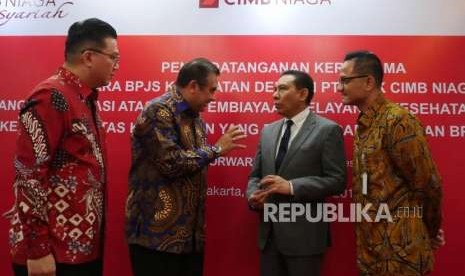 Direktur Syariah Banking CIMB Niaga Pandji P. Djajanegara (kedua kiri)  bersama Direktur Keuangan dan Investasi BPJS Kesehatan Kemal Imam Santoso (kedua kanan), Chief of Corporate Banking CIMB Niaga Rusly Johannes (kiri) dan Deputi Direksi Bidang Treasury dan Investasi BPJS Kesehatan Fadlul Imansyah berbincang usai acara penandatanganan nota kesepahaman CIMB Niaga dan BPJS Kesehatan di Jakarta, Rabu (12/9).