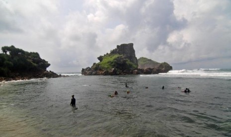 Sejumlah wisatawan bermain air di Pantai Nglambor di Tepus, Kabupaten Gunung Kidul, DI Yogyakarta, Sabtu (19/11).