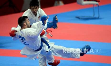 Karateka Indonesia Arrosyiid Rifki Ardiansyah (pita merah) saat melawan karateka Iran Amir Mahdi Zadeh pada pertandingan cabang olahraga karate Asian Games 2018 kategori kumite 60 kilogram di JCC Plennary Hall, Jakarta, Ahad (26/8).