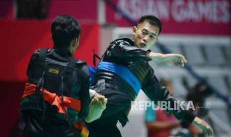 Pesilat Indonesia Iqbal Candra Pratama (pita biru) bertanding melawan Pesilat Malaysia Mohamad Zarish Hakim Shukor pada babak perempat final cabang pencak silat putra kelas D 60-65 kg Asian Games 2018 di Padepokan Pencak Silat TMII, Jakarta, Jumat (24/8).