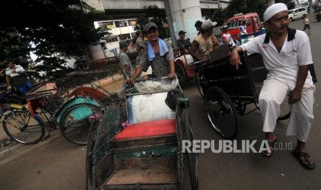 Tukang becak saat menunggu untuk didata oleh petugas di kolong flyover Bandengan Utara, Pekojan, Tambora, Jakarta Barat, Jumat (26/1).