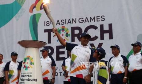 Gubernur DKI Jakarta Anies Baswedan membawa obor saat Torch Relay Asian Games 2018 di Kawasan Kramat Jati, Jakarta, Rabu (15/8).