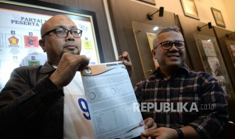 Penerimaan Rekapitulasi Pilkada Serentak. Ketua KPU Arief Budiman (kanan) bersama Komisioner KPU Ilham Saputra menunjukkan laporan terkait Pilkada Serentak di KPU Pusat, Jakarta, Ahad (8/7).