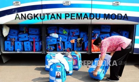 Petugas memasukan tas calon jamaah haji ke dalam bagasi bus sebelum berangkat ke Bandara Soekarno Hatta di Asrama Haji Pondok Gede, Jakarta, Rabu (18/7).