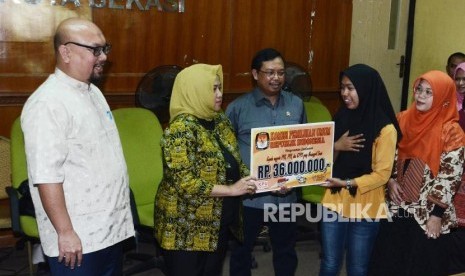 Santunan KPU korban Wafat. Komisioner KPU Pusat Ilham Saputra (kiri), Wakil Ketua Komisi II DPR Herman Khaeron (tengah) dan Ketua KPU Bekasi Nurul Sumarheni (kanan) memberikan santunan kepada ahli waris petugas pemungutan suara yang wafat di Kota Bekasi, Jawa Barat, Jum'at (12/7).