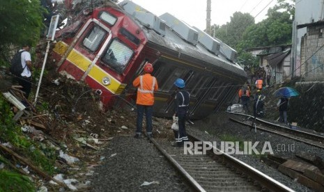 Petugas mengevakuasi KRL Commuter Line 1722 yang anjlok di pintu perlintasan Kebon Pedes, Tanah Sareal, Bogor, Jawa Barat, Ahad (10/3).