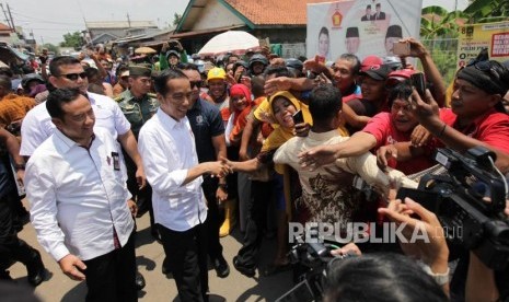 Presiden Joko Widodo bersama Bupati Cilacap Tatto Suwarto Pamuji (kiri) menyapa warga saat meninjau barang kebutuhan pokok di Pasar Pelemgading, Cilacap, Jawa Tengah, Senin (25/2). Ilustrasi.