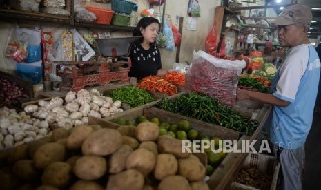 Pedagang sayuran melayani pembeli di Pasar Rumput, Jakarta, Senin (1/7).