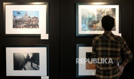 Mahasiswa mengamati karya foto yang di pamerkan dalam pameran fotografi jurnalistik di selasar Universitas Nasional, Jakarta, Senin (20/11).