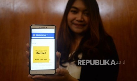 Seorang wajib pajak menunjukan informasi mengenai pengisian SPT secara online di Jakarta, Jumat (9/3).