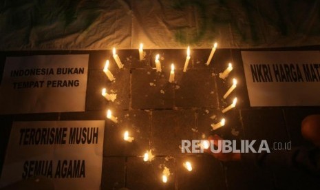 Seorang suporter menyalakan lilin saat aksi solidaritas terkait aksi tragedi teror bom di Surabaya dan Siduarjo di Taman Suropati, Jakarta, Senin (14/5).