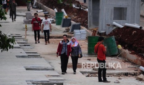 Warga berjalan kaki di dekat proyek penataan trotoar di kawasan Sudirman, Jakarta Pusat.