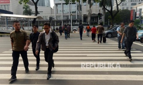 Sejumlah warga menyeberangi pelican crossing di Jalan Jenderal Sudirman, Jakarta.