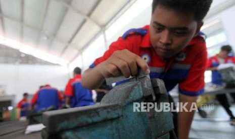 Siswa Sekolah Menengah Kejuruan (SMK) mengukur benda kerjanya saat praktik mesin di SMK Negeri 1, Jakarta, Senin (1/10).