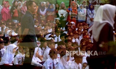 Orang tua murid mengawasi anaknya pada hari pertama masuk sekolah di SDN Kampung Melayu 01/02, Jakarta, Senin (16/7).