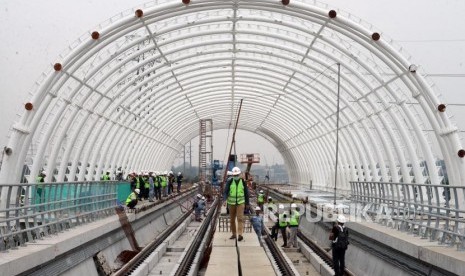 Pekerja beraktivitas di Stasiun LRT Taman Mini, Jakarta, Senin, (14/1).