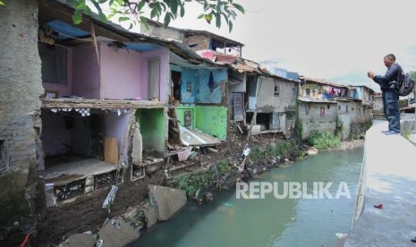 Seorang wartawan memotret kondisi rumah yang ambruk di pinggiran Sungai Citepus, Kawasan Sirnaraga, Kota Bandung.