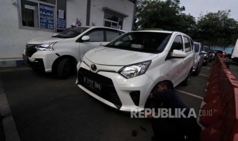 Uji Kir Angkutan Online. Petugas melakukan pengecekan saat uji kendaraan bermotor (Kir) angkutan berbasis aplikasi daring (online) di Pengelola Pengujian Kendaraan Bermotor, Pulogadung, Jakarta Timur, Rabu (1/11).