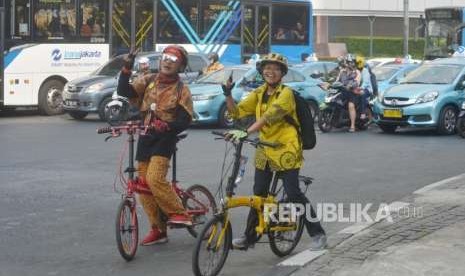 Peseda mengenakan pakaian batik saat bersepeda di kawasan Bundaran Hotel Indonesia, Jakarta Pusat, Selasa (2/10).