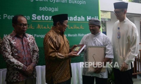 Dirut Bank Syariah Bukopin (BSB) Saidi Mulia Lubis (kanan) bersama Pengawas Pelaksana Badan Pengelola Keuangan Haji (BPKH) Suhaji (kiri) dan Ketua Dewan Kemakmuran Masjid Sunda Kelapa Aksa Mahmud (kedua kanan) berbincang bersama nasabah BSB pada acara launcing bank syariah bukopin sebagai bank penerima setoran ibadan haji di masjid Agung Sunda Kelapa, Jakarta, Senin (9/7).