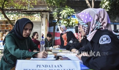 Petugas Disdukcapil memeriksa kelengkapan dokumen kependudukan warga 