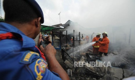 Kebakaran. Petugas pemadam kebakaran DKI Jakarta  sedang melakukan pemadaman api yang membakar rumah penduduk di Mampang Parapatan dua, Jakarta Selatan, Ahad (22/10).